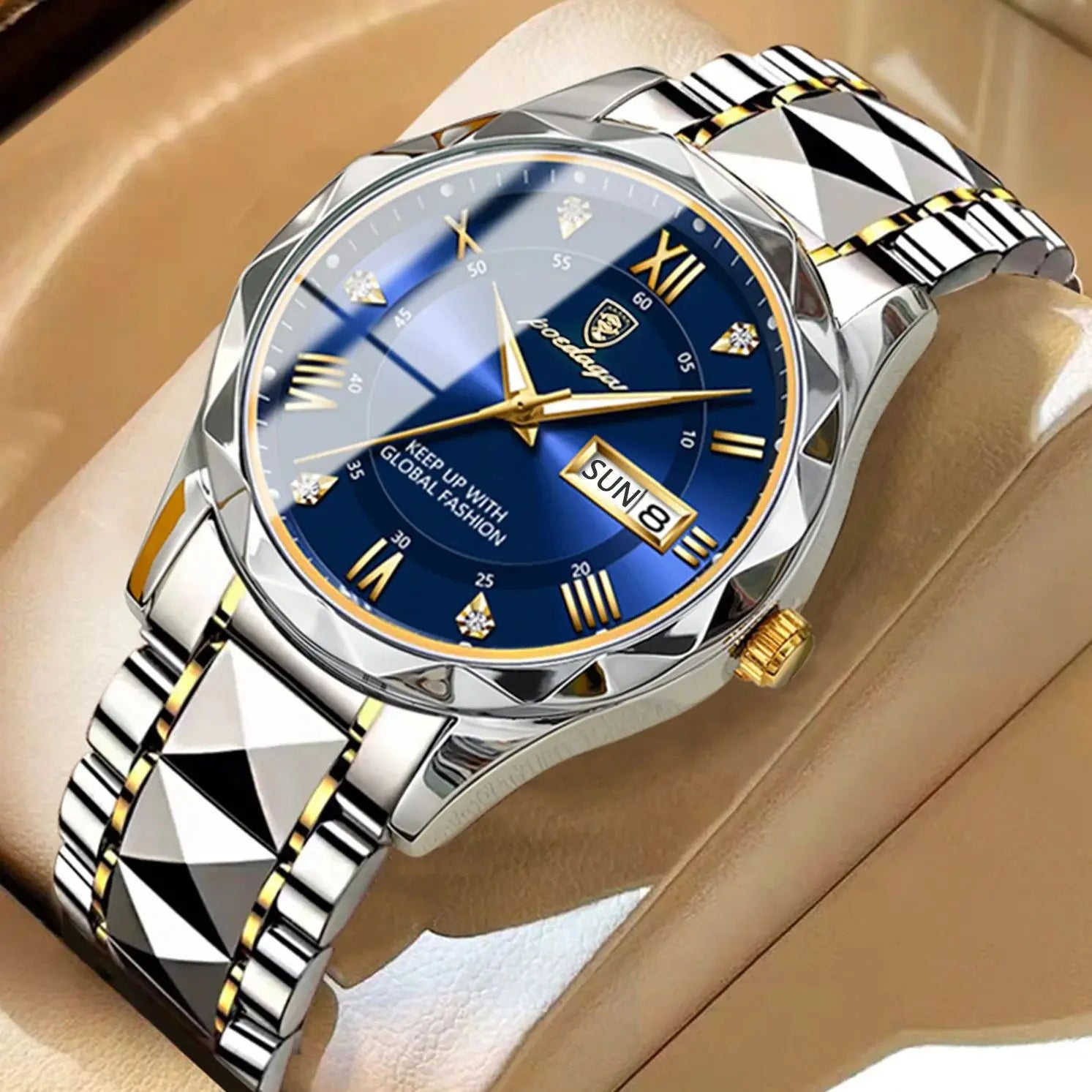 Silver and gold watch with blue face on a beige surface